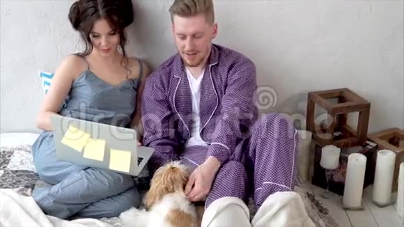 年轻夫妇穿着睡衣坐在床上视频的预览图