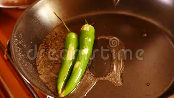 咖喱叶被扔进锅里里面放着香料辣椒和调味品视频的预览图