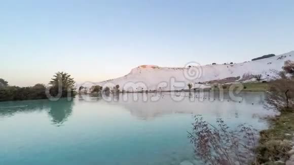 太阳升起在帕穆卡莱土耳其与白山和它的反射在自然游泳池延时4k视频的预览图