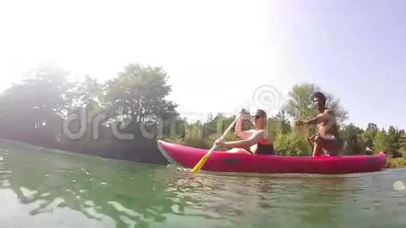 可爱的情侣在划独木舟的时候看着摄像机视频的预览图
