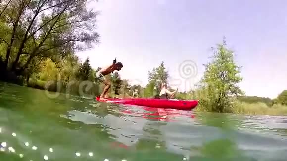 男人从独木舟倒回水面女孩则划独木舟视频的预览图
