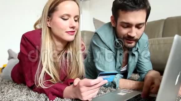 女人拿着信用卡男人解释什么两个人都躺在地毯上视频的预览图