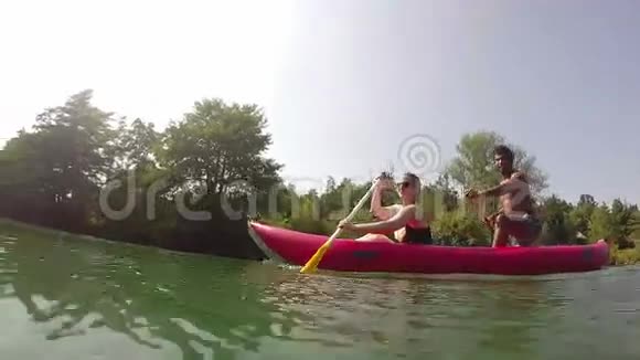 可爱的情侣在划独木舟的时候看着摄像机视频的预览图