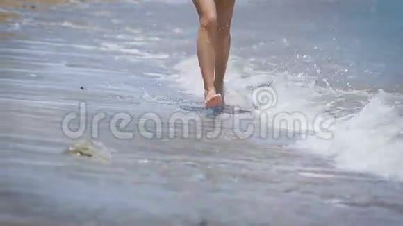 一个美丽的女孩在海滩上奔跑的腿视频的预览图