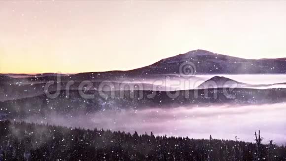 圣诞节的早晨下雪而粉红色的橙色日出在雾蒙蒙的冬山之上雾蒙蒙的山谷之上的山峰视频的预览图