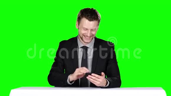商人坐在桌边用电话绿色屏幕视频的预览图