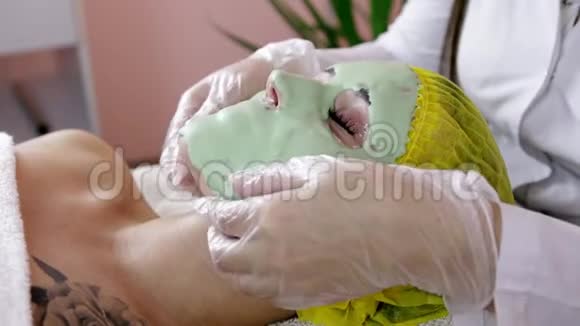 美丽的黑发女人在健康水疗中心接受面部护理视频的预览图