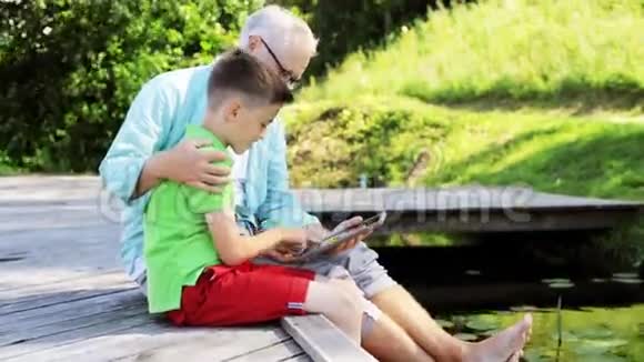祖父和男孩带着平板电脑在河泊33号视频的预览图