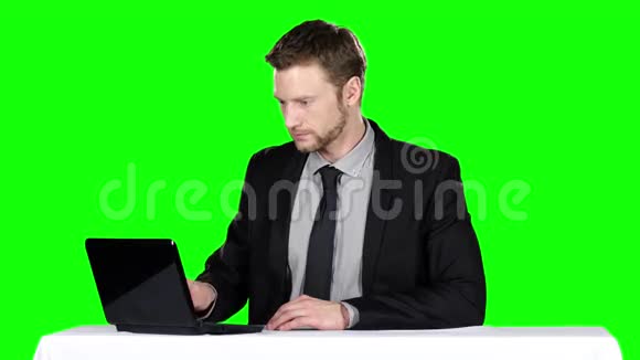商人坐在桌子旁用笔记本绿色屏幕视频的预览图