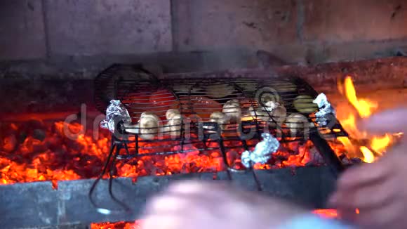 厨师正在把鱼和蔬菜放在火上视频的预览图