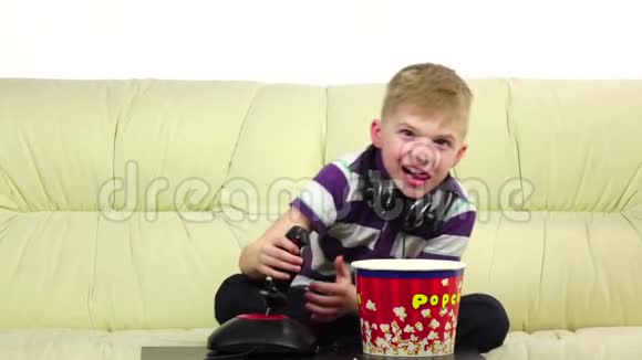 小孩吃爆米花玩操纵杆在线游戏慢动作视频的预览图