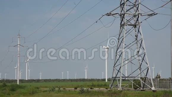 风力涡轮机在后台电力线路在前景视频的预览图