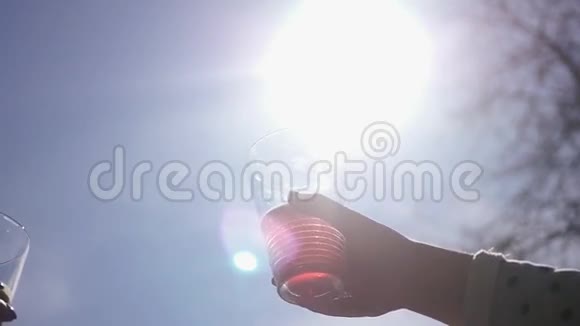 在蓝天和明亮的太阳的背景上用饮料夹着眼镜的效果高清1920x1080视频的预览图