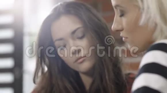 在现代阁楼公寓学习的两个漂亮的年轻女孩视频的预览图
