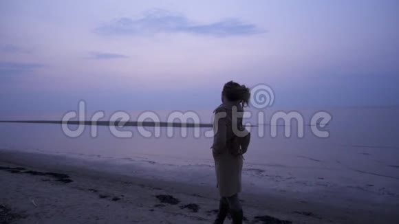 寒冷的一天美丽的女人在海边视频的预览图