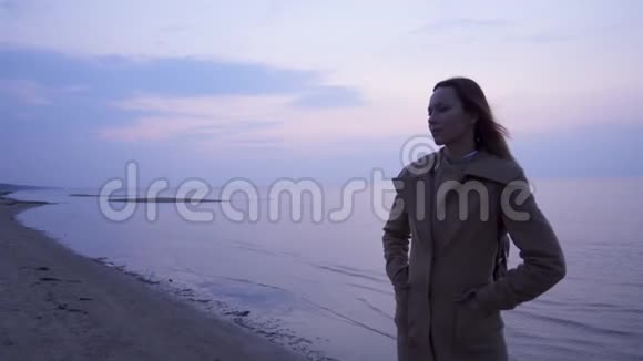 寒冷的一天美丽的女人在海边视频的预览图