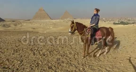 吉萨金字塔建筑群中的美女骑马视频的预览图