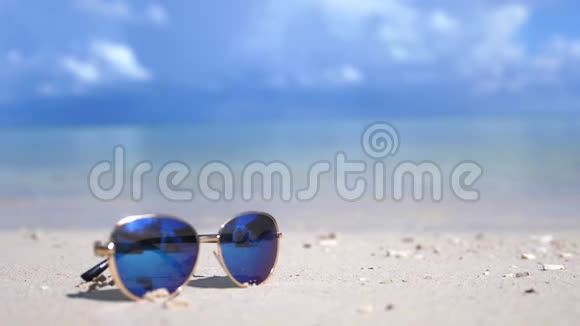 旅游度假理念白色海滩上的蓝色太阳镜蓝绿色海的背景与副本视频的预览图