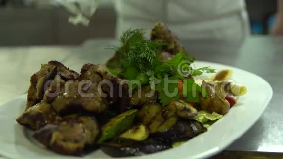 厨房餐厅做饭厨师用青菜装饰烤肉视频的预览图