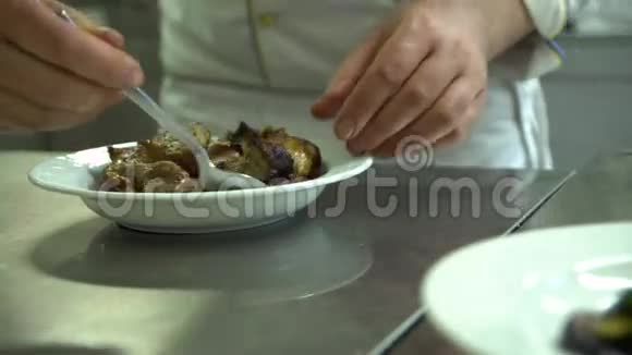 厨房餐厅做饭厨师把肉烤好放在一盘蔬菜上视频的预览图