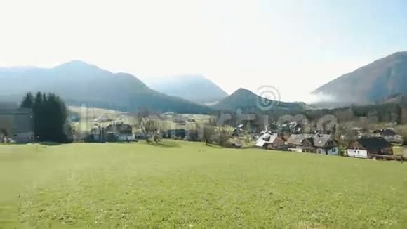 这片草地的全景覆盖着群山背景下的小木屋拥抱视频的预览图