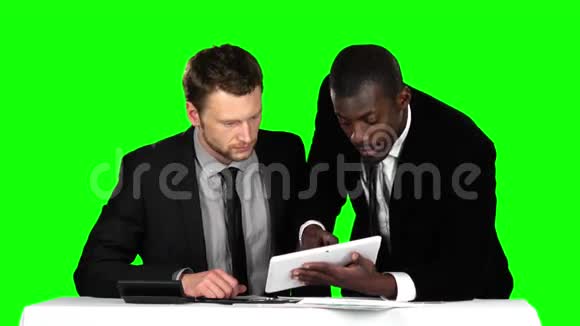 两个成功的商人坐在办公室的谈判桌前在他的笔记本电脑上工作绿色屏幕视频的预览图