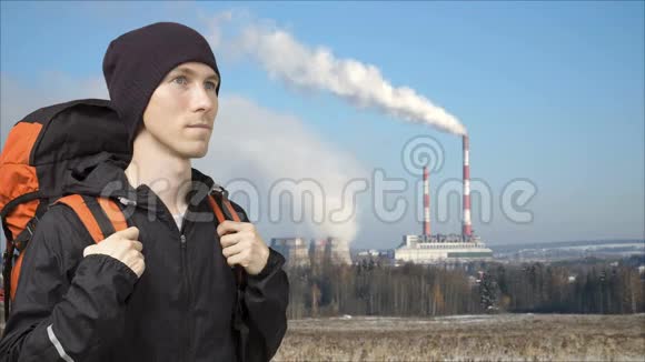 工厂的烟斗和前景中背包的人循环视频电影摄影视频的预览图