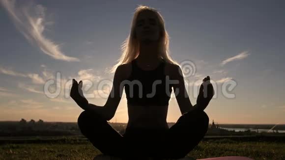 剪影运动亚洲女子瑜伽在海滩日落视频的预览图