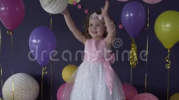 在生日聚会上一个漂亮的小女孩笑着玩气球视频的预览图
