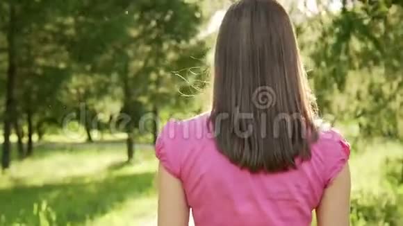 波夫无忧无虑开朗的黑发在公园散步放松的暑假后面的摄像头视频的预览图