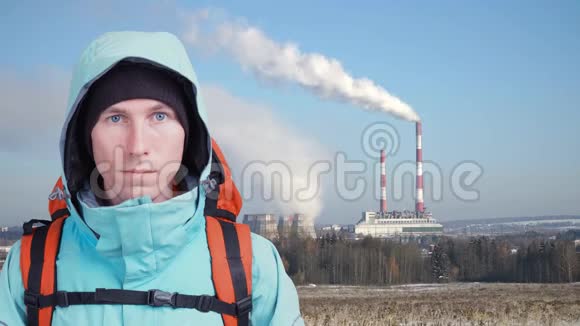 工厂的烟斗和前景中背包的人循环视频电影摄影视频的预览图