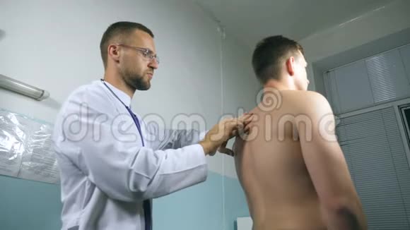 医生检查了她医院办公室里的家伙医生用听诊器检查年轻男性病人医疗视频的预览图