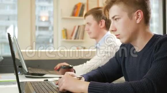 在项目上的笔记本电脑办公室工作的年轻人专注于键盘打字和看屏幕这就是视频的预览图