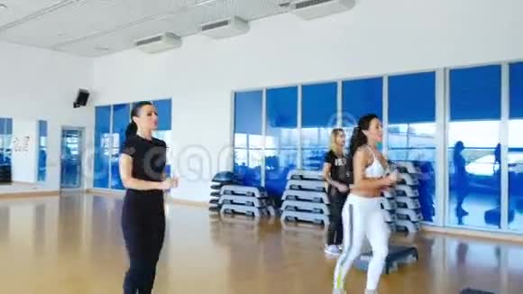 年轻的运动女性在健身房里训练踏步健美操视频的预览图