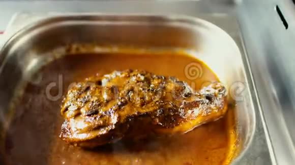 在餐厅的厨房里用肉汁烧汁将热肉菜旋转视频的预览图