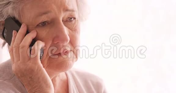 伤心的老女人在用手机说话视频的预览图