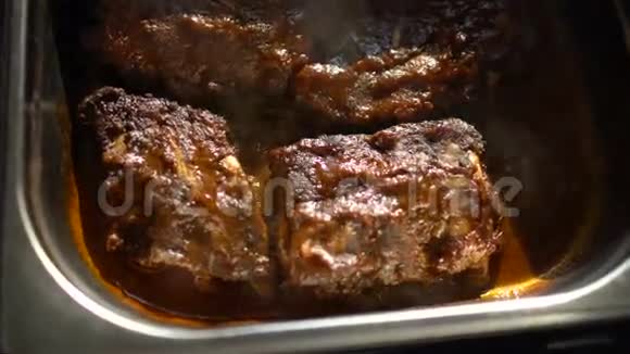 在餐厅的厨房里用肉汁烧汁的排骨旋转热肉菜视频的预览图
