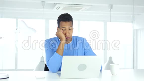 正在睡觉的美国黑人青年坐在办公室里视频的预览图