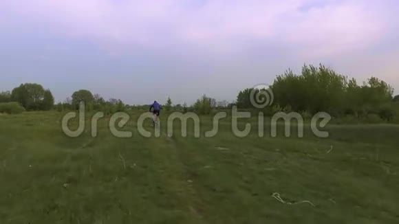 骑自行车的人骑在春绿的草地上视频的预览图