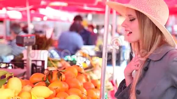 市场上的金发女孩在采摘橘子视频的预览图