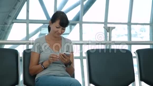在空的机场等候区用电话的女人视频的预览图