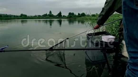 渔夫用网钓鱼鱼咬鱼饵鱼在网上飞溅夏季捕鱼视频的预览图