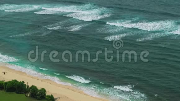 印尼巴厘岛乌卢瓦图恩加兰海滩海岸线上的波浪移动视频的预览图