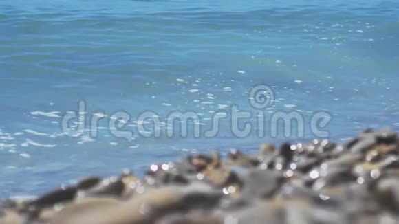 海边的一片岩石海滩阳光明媚的一天海浪慢动作1920x1080视频的预览图