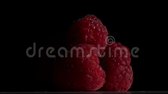 覆盆子果实是在黑色背景上旋转的关门视频的预览图