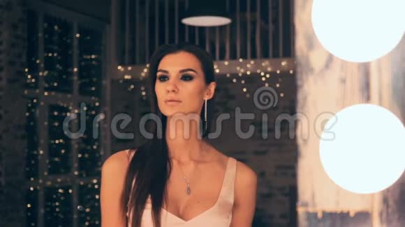 穿着晚礼服的优雅女孩在更衣室灯光下的镜子前摆姿势的肖像布鲁内特视频的预览图