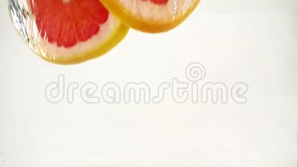 柚子橙片落入水中溅起水花和气泡慢动作特写视频的预览图