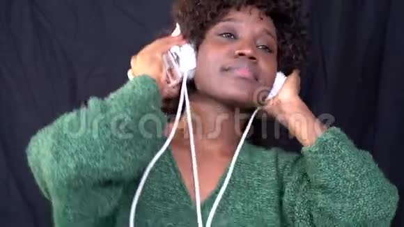 在录音室听耳机音乐的非裔美国妇女视频的预览图