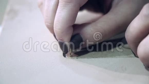 在一个创意工作室里设计师的手把钉子插在相框里视频的预览图