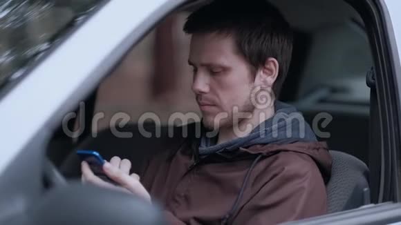 司机坐在车里用智能手机视频的预览图